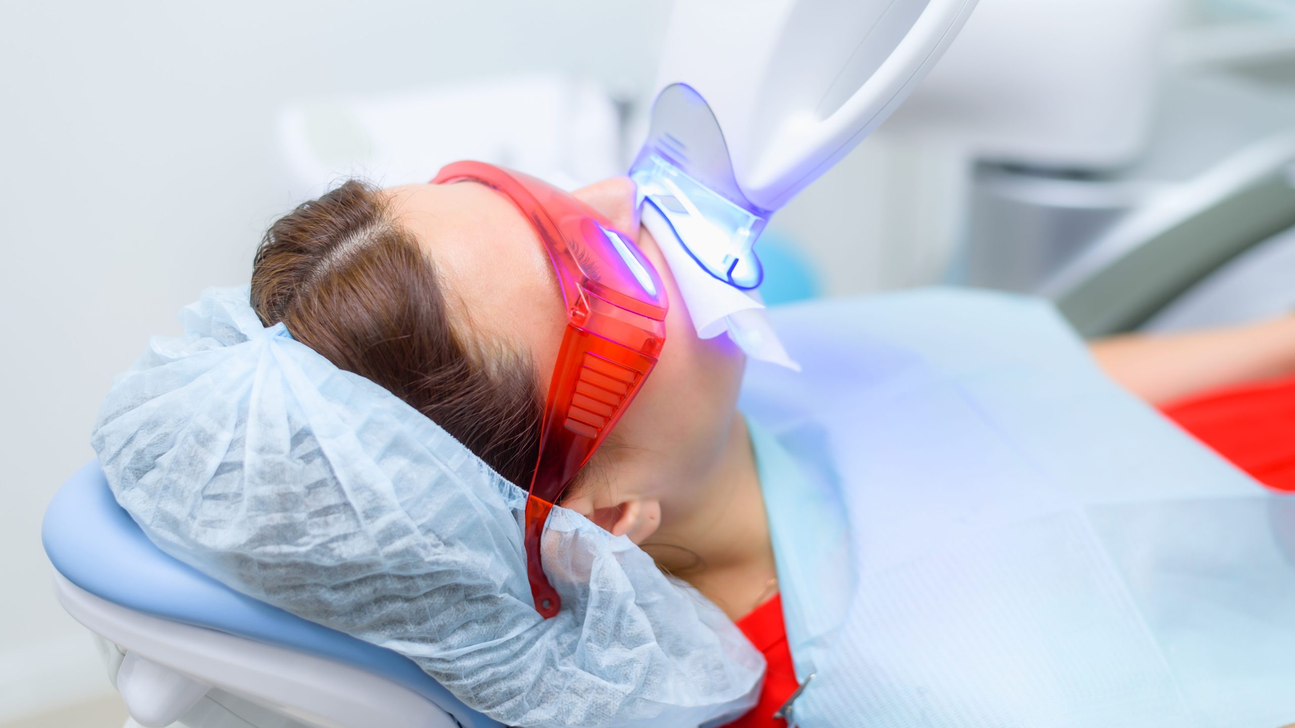 the patient undergoes a procedure for teeth whitening with an ultraviolet lamp