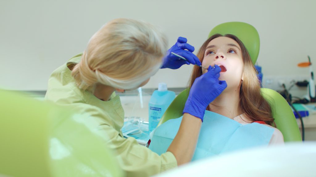 Doctor working with patient in modern dental clinic. Female dentist
