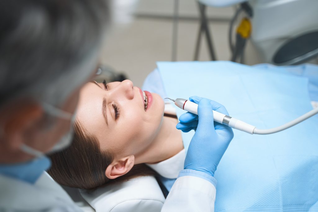 Dentist is treating young woman stock photo