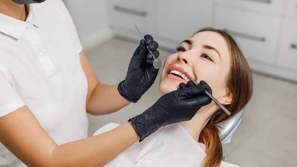 Banner for dental theme. Close-up of female smile with white teeth during medical examination. Concept of tooth whitening, treatment, veneers, professional clinic. Photo with free copy space