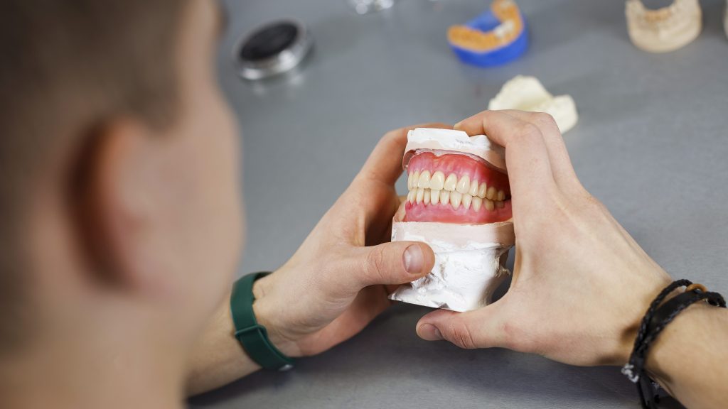 dental technician works with dentures of both jaws and compares
